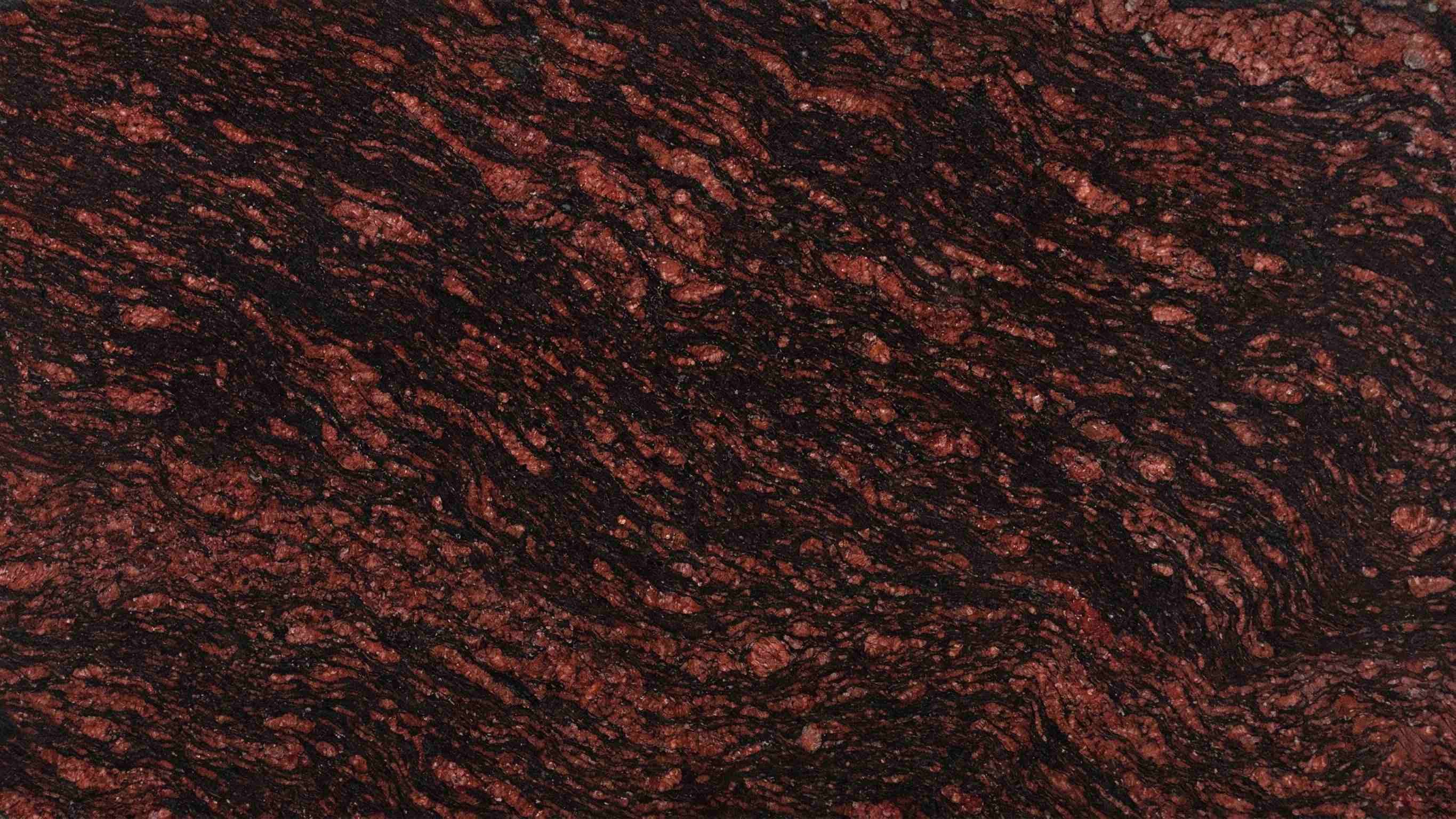 Premium Himalayan Brown Indian Granite featuring majestic waves of mahogany and amber. High-quality polished slab supplied wholesale in Kishangarh.