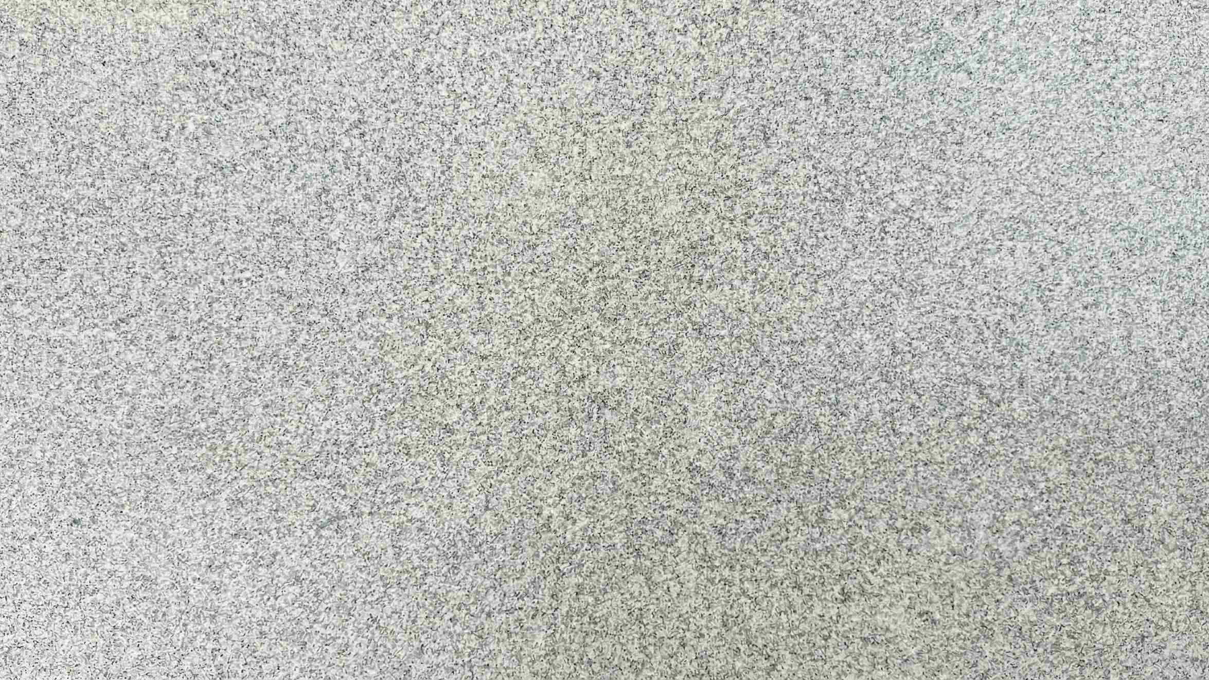 Premium Jeerawal White Indian Granite featuring a soft white background delicately peppered with natural grey minerals. High-quality polished slab supplied wholesale in Kishangarh.