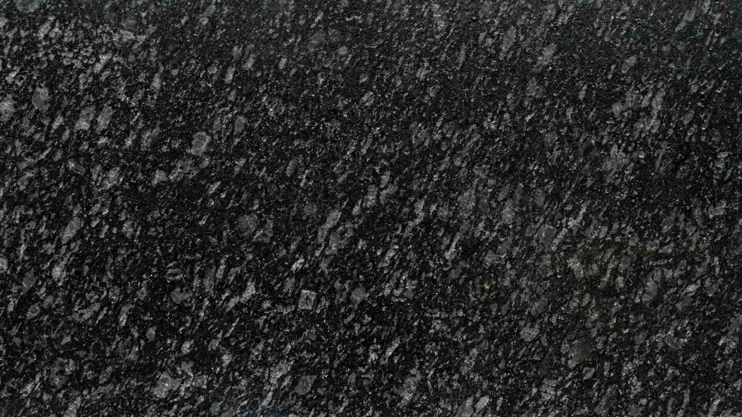Premium Pearl Black Lapatro Indian Granite featuring pearlescent flecks on a black canvas with a tactile leathered finish. High-quality polished slab supplied wholesale in Kishangarh.